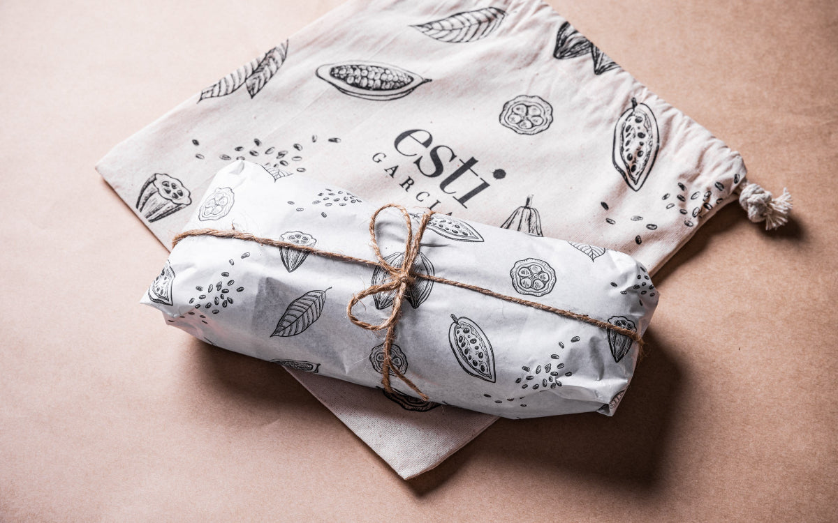 Packaged product with decorative string on a light pink background